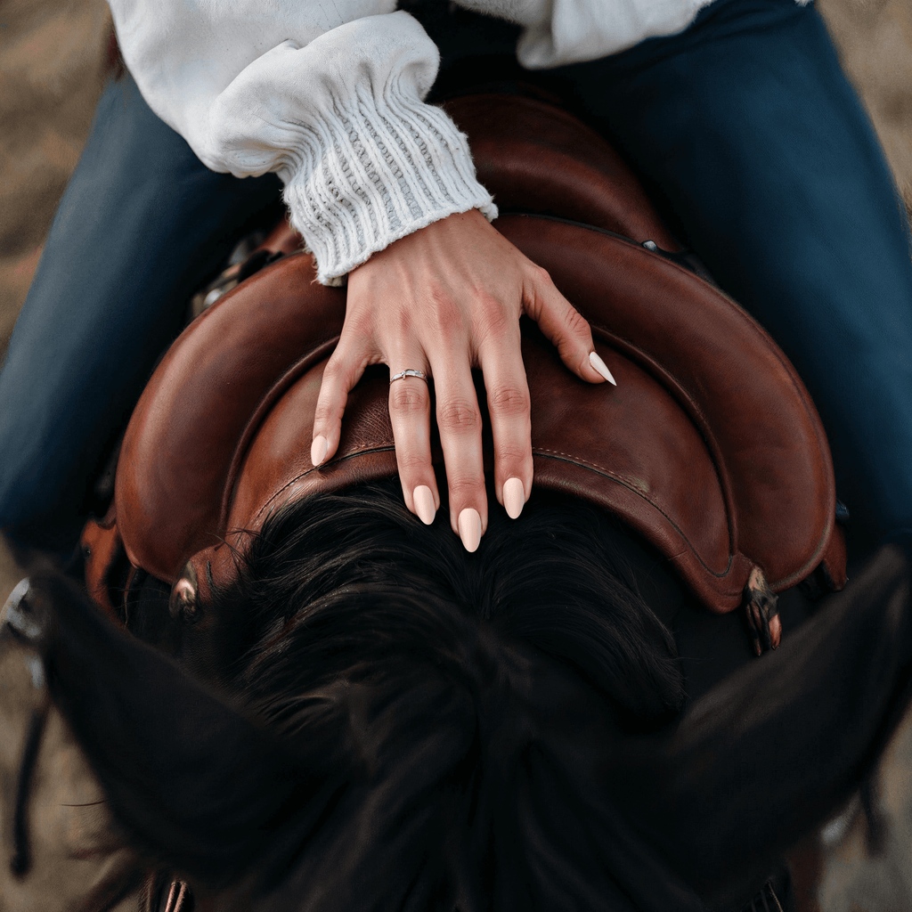 woman on top of a horse showing her nails